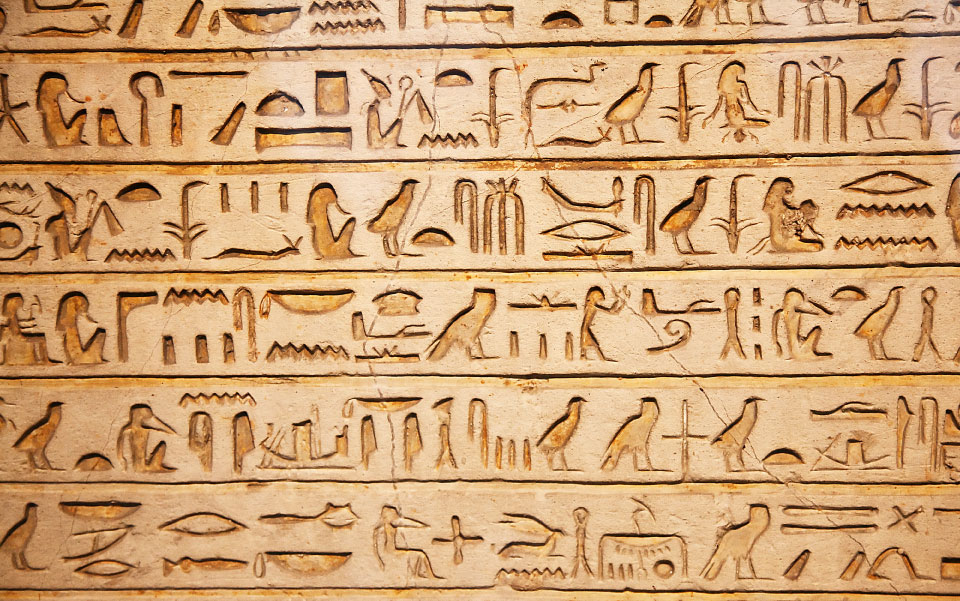 A close up of the egyptian hieroglyphs on a wall