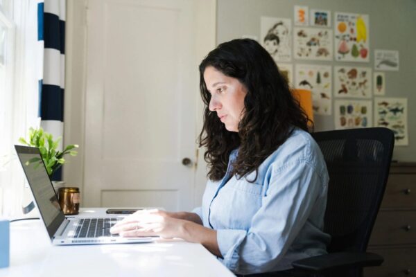 A woman sitting at her desk with a laptop.