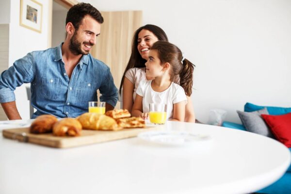 A man and woman sitting at the table with a girl.