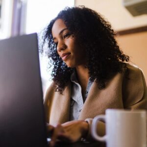 A woman sitting at a table with a laptop.