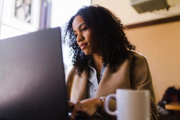 A woman sitting at a table with a laptop.