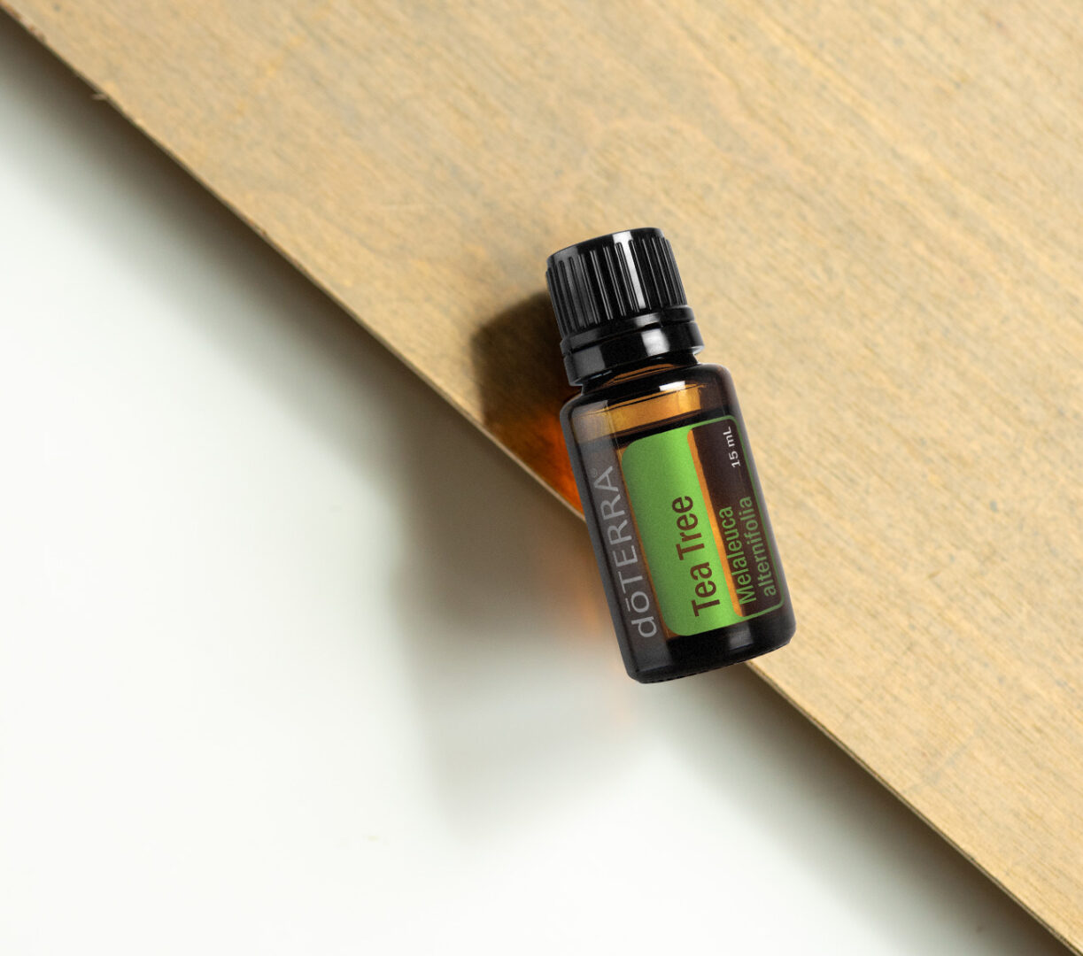 A bottle of essential oil sitting on top of a wooden surface.