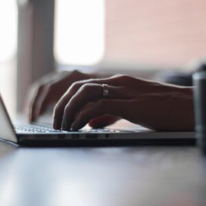 A person typing on a laptop computer.