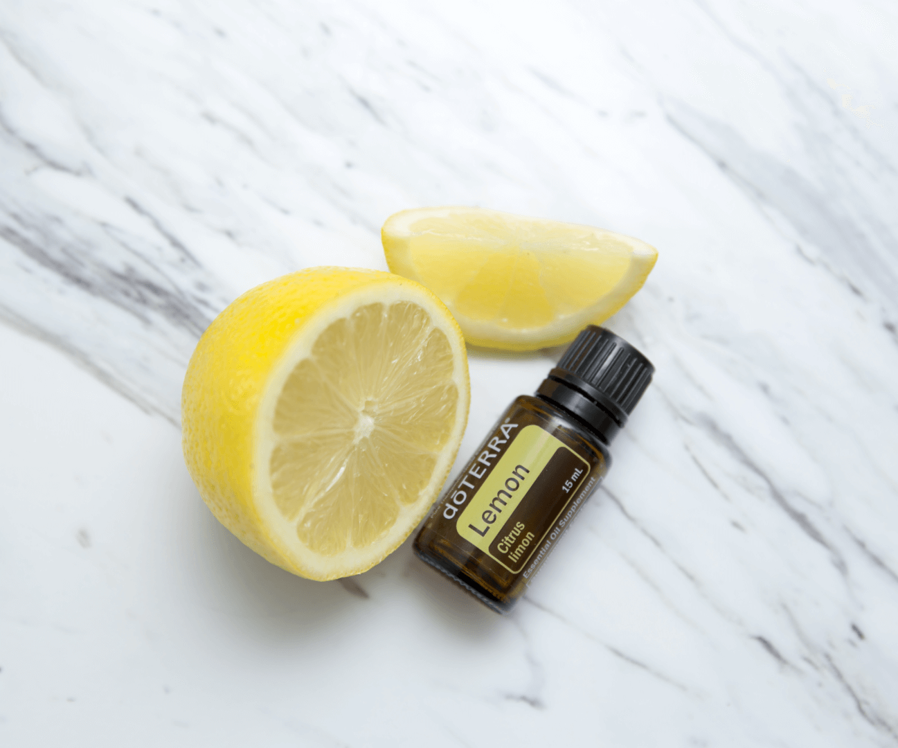 A lemon and an essential oil bottle on a table.